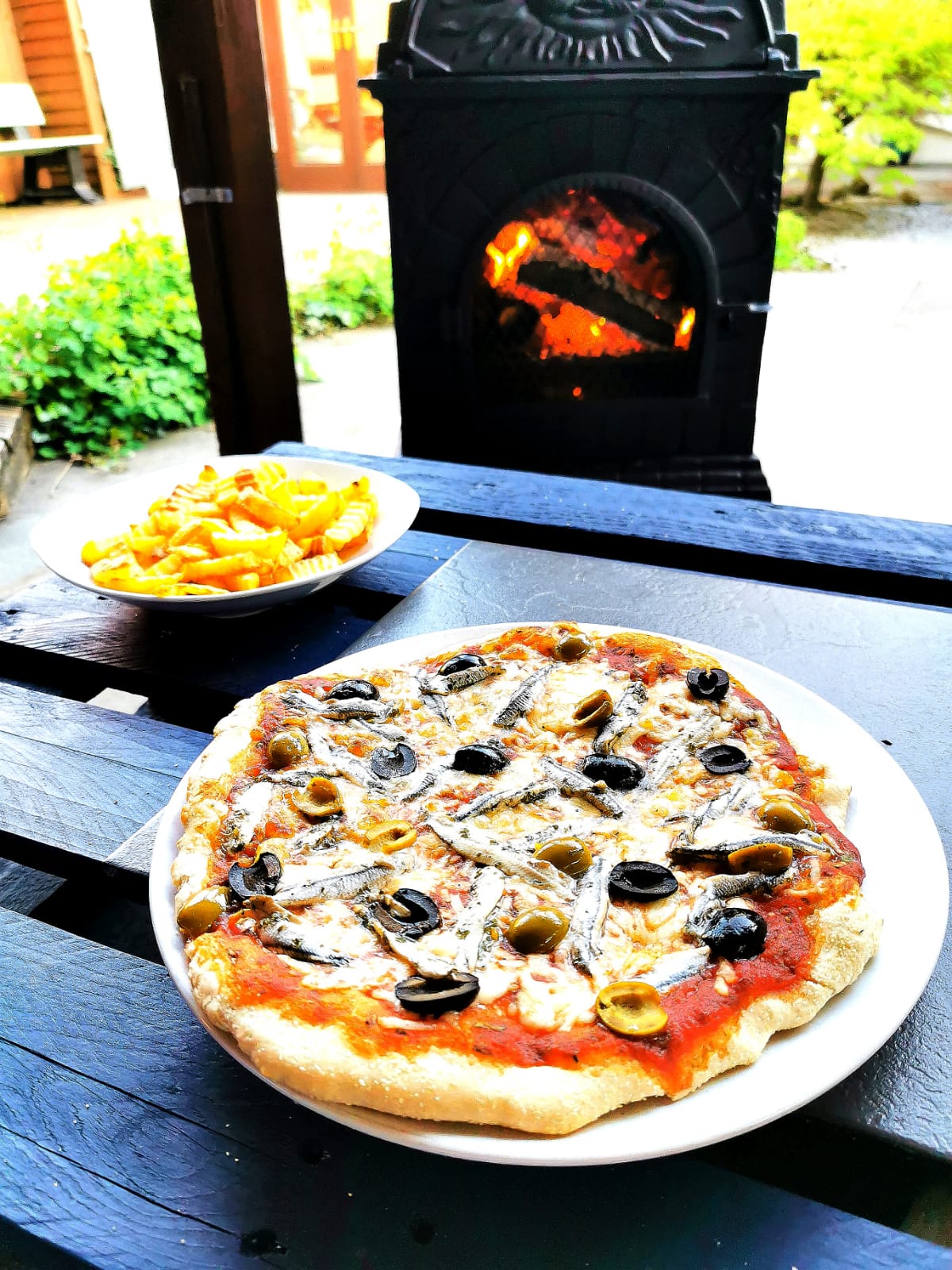 Mushroom pizza in front of a wood burning stove